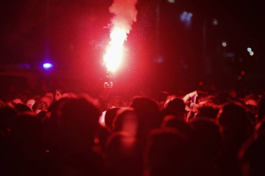 Futbol maçında elinde meşale tutan bir adamın elleri ile ilgili detaylar..