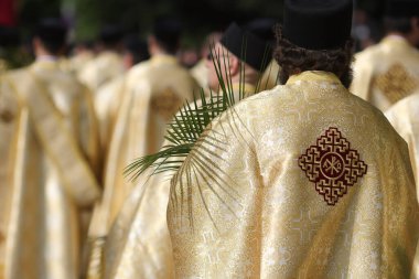 Palmiye yaprakları tutan Romen Ortodoks rahipler, Pazar günü düzenlenen Palm Sunday geçit töreninde Bükreş sokaklarında yürüyorlar.
