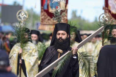 Bükreş, Romanya - 27 Nisan 2024: Palmiye yaprakları tutan Romen Ortodoks rahipler Pazar günü düzenlenen bir hac alayında Bükreş sokaklarında yürüyorlar.