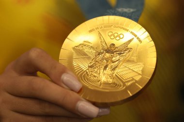 Otopeni, Romanya - 7 Ağustos 2024: Paris 2024 Olimpiyatlarında altın madalya kazanan Romen bir atletin elleriyle ayrıntılar.