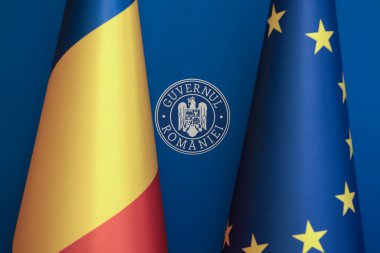 Romanya ve Avrupa Birliği bayrakları arasında Romen Hükümeti logosu.