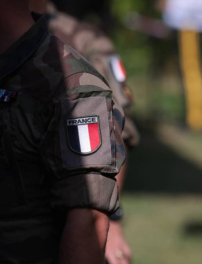 Bir askerin askeri üniformasında Fransız bayrağıyla sığ alan derinliği (seçici odak) ayrıntıları.