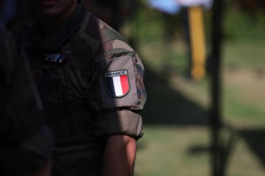 Shallow depth of field (selective focus) details with the French flag on the military uniform of a soldier. clipart