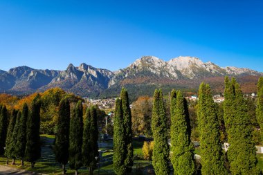 Arka planda Bucegi Dağları ve Caraiman Tepesi ve güneşli bir sonbahar gününde Busteni şehri.