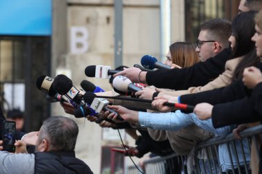 Bükreş, Romanya - 7 Mart 2025: Medya temsilcileri bir politikacıya mikrofon tutuyorlar.