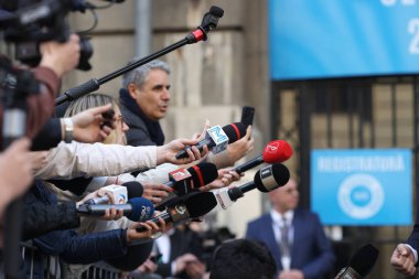 Bükreş, Romanya - 7 Mart 2025: Medya temsilcileri bir politikacıya mikrofon tutuyorlar.