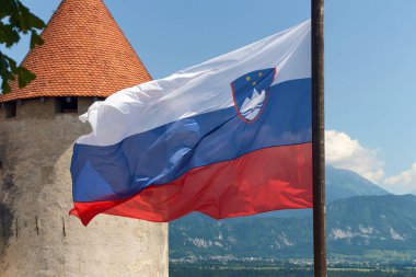 Bled Castle arka planında Slovenya Ulusal Bayrağı sallıyor