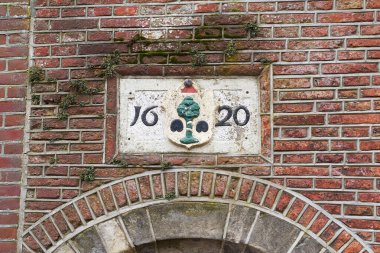 Delft, the Netherlands. 17th century sign on the old building. clipart