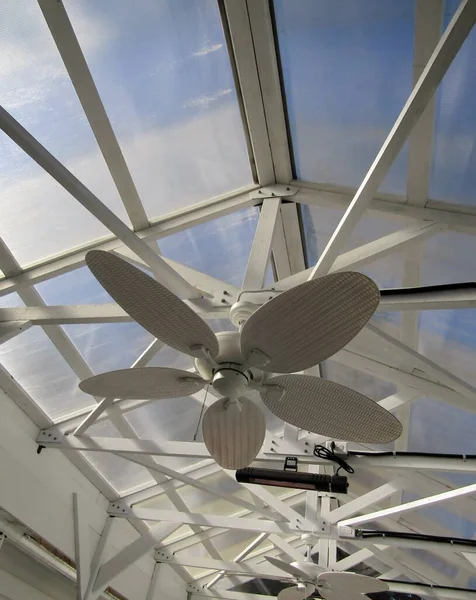 White ceiling fan and outdoor heater in patio with clear polycarbonate sheet roof