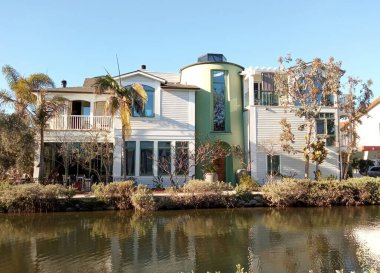 Venice Beach, Los Angeles, CA, ABD 'de bir kanal boyunca evler ve palmiye ağaçları