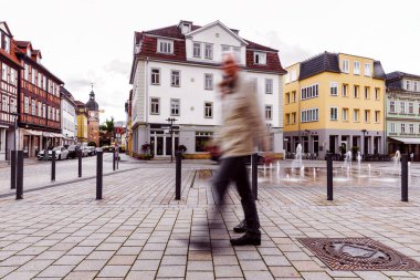 Coburg, Bavyera 'da Albertplatz' da yürüyen yaşlı bir adam sıcak bir günde tarihi mimari ve Avrupa şehir atmosferini gösteriyor.