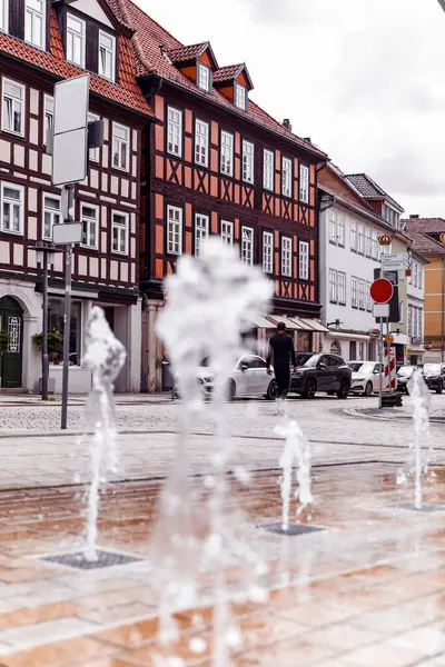 Albertplatz Coburg Bavyera 'daki tarihi binalar üzerinde yoğunlaşırken, fıskiyeler ön planda bulanıklaştı. Güneşli bir gün, şehir manzarası mimari ve hareketi harmanlıyor.