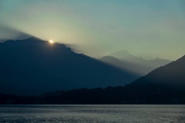 Gün doğumu dağ vadilerinde parlayan güneş ışınları ve dağın tepesinde parlayan güneş.