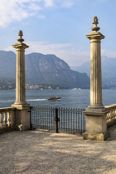 ornamental balustrade columns and gates leading to boat landing on the shore of lake como at bellagio sunny day