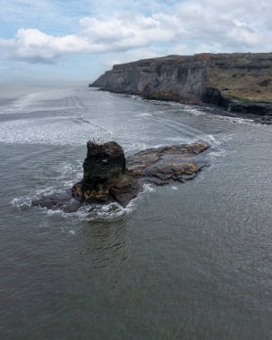 Whitby North Yorkshire yakınlarındaki Saltwick Körfezi 'nde siyah Nab. Gelgitte yükseldi.