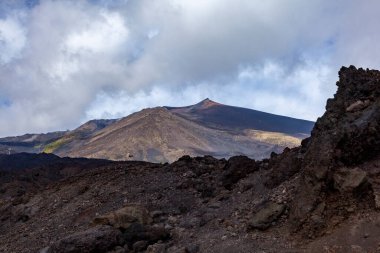 Sicilya 'da etna tepesinin zirvesi açık bir günde, ön planda katı lav duvarıyla hareketsiz.