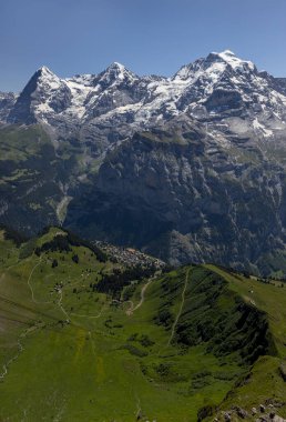 Bernese Oberland 'deki Murren Köyü' nün yukarısındaki Eiger Monch ve Jungfrau dağları Birg güneşli, mavi gökyüzü tek renkli gökyüzü.