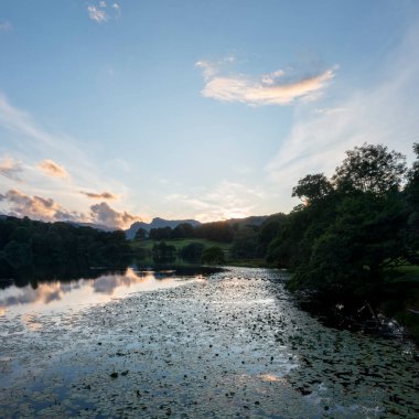 Loughrigg Tarn Langdale göl bölgesi cumbria uk, günbatımında, nilüferler yükselmiş manzaralı.