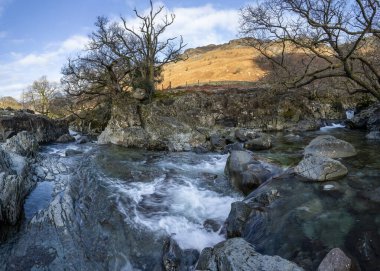 Güneşli bir kış gününde Borç Göl Bölgesi Cumbria Uk 'taki Stonethwaite Beck' in üzerine sertçe şelale.