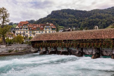 Schleusen ahşap yaya köprüsü ve Thaun İsviçre 'deki aare nehri üzerinde Weir.