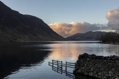 Kış günbatımı döküntü su gölü bölgesi cumbria 'da çitleri ve duvarı olan hiç kimse