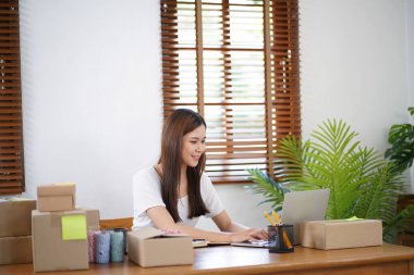 Business From Home Asian woman preparing package delivery box Shipping for shopping online. young start up small business owner at home online order.