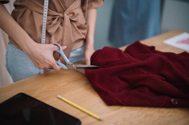 Terzide çalışan terzi kadın atölye atölyesinde moda tasarımcısı yeni bir koleksiyon tasarlıyor.