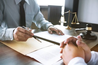 Hukuk danışmanı müvekkiline tokmak ve hukuk hukuku ile imzalanmış bir sözleşme sunar. Adalet ve avukat kavramı