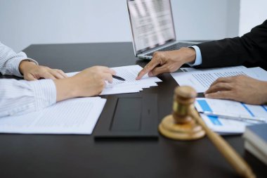 Hukuk danışmanı müvekkiline tokmak ve hukuk hukuku ile imzalanmış bir sözleşme sunar. Adalet ve avukat kavramı.