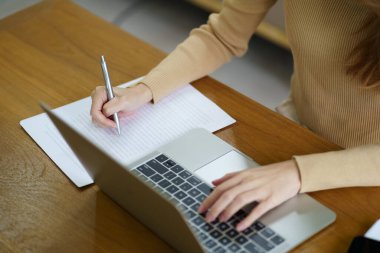 Evden çalışan bir iş kadını. Bilgisayarda çalış. Asyalı iş kadını internette sosyal mesafeli dizüstü bilgisayarla kanepe üzerinde çalışıyor.