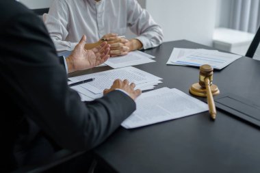 Avukat hukuk danışmanı müvekkiline tokmak ve hukuk hukuku ile imzalanmış bir sözleşme sunar. Adalet ve Avukat İş ortaklığı toplantısı konsepti