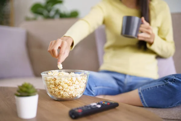 stock image Asian woman Watching smart TV and using remote controller Hand holding television audio remote control at home with the remote control television