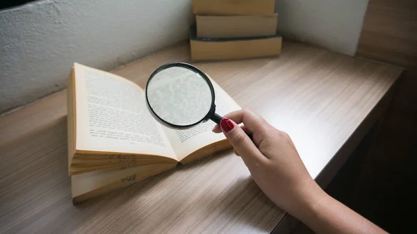 Books and a magnifier Research concept. Magnification glass over opened book