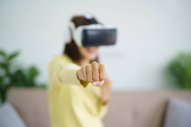 Genç Asyalı kadın oyuncu sanal gerçeklik giyip VR deneyimi sırasında havaya dokunuyor gelecekteki ev sahibi teknoloji oyuncusu oyuncu eğlenceli eğlence konsepti