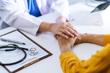 Doctor healthcare. Professional medical doctor in white uniform gown coat interview consulting patient reassuring his male patient helping hand