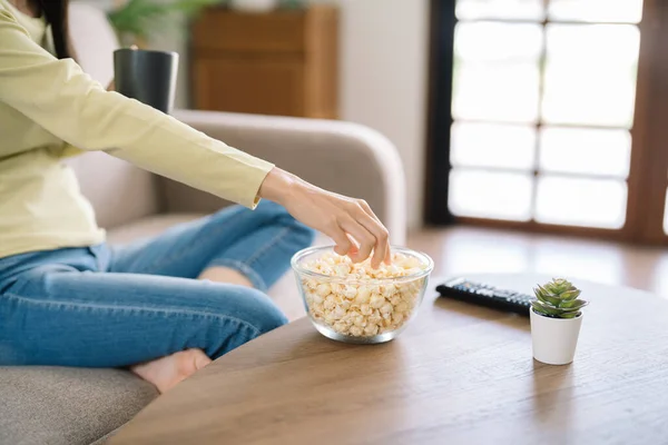 stock image Asian woman Watching smart TV and using remote controller Hand holding television audio remote control at home with popcorn