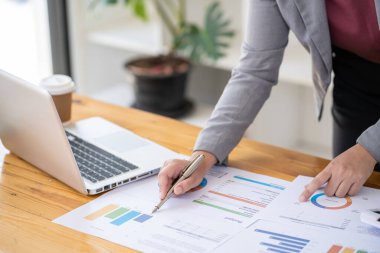 Yatırım grafiklerini analiz eden iş kadını muhasebeci ve belgelerin üzerindeki hesap makinesi tuşlarına basıyor. Muhasebe Muhasebecisi Banka Danışmanı ve Denetçi Konsepti.