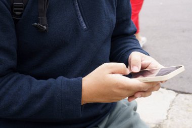 Şehir merkezinde bir adam akıllı telefon uygulaması kullanarak taksi sipariş ediyor. Akıllı telefondaki uygulamayı kullanarak..