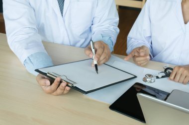 Doctor healthcare. Professional medical doctor in white uniform gown coat interview consulting patient reassuring his male patient helping hand.