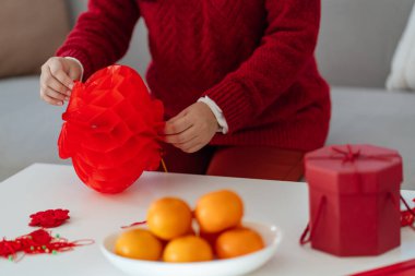 Asian Woman holding red Chinese new year lantern while decorated flat putting traditional pendant to the Chinese New Year Celebrations for good luck. chinese word means blessing.