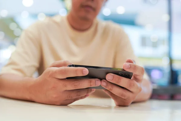 Man playing game on mobile phone. gamer boy playing video games holding Smartphone working mobile devices. cell telephone technology e-commerce concept.
