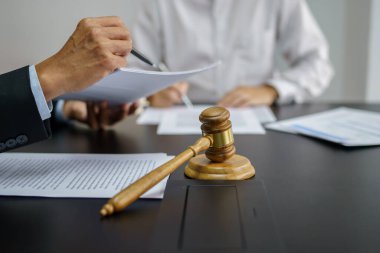 Hukuk danışmanı müvekkiline tokmak ve hukuk hukuku ile imzalanmış bir sözleşme sunar. Adalet ve avukat kavramı.
