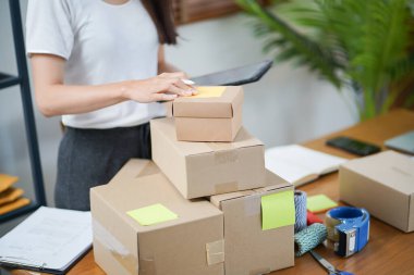 Business From Home Asian woman preparing package delivery box Shipping for shopping online. young start up small business owner at home online order.