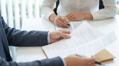 Avukat hukuk danışmanı müvekkiline tokmak ve hukuk hukuku ile imzalanmış bir sözleşme sunar. Adalet ve Avukat İş ortaklığı toplantısı
