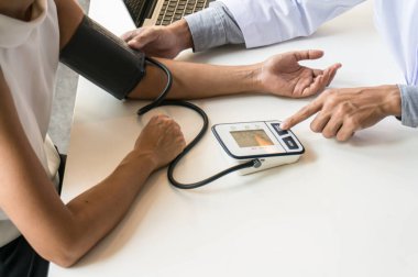 Doktor Sağlık Hizmetleri. Beyaz üniformalı profesyonel tıp doktoru hastasına danışmanlık yapıyor ve erkek hastasına yardım ediyor. 