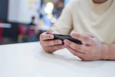 Cep telefonuyla oyun oynayan adam. Oyuncu çocuk elinde akıllı telefon, cep telefonuyla video oyunu oynuyor. cep telefonu teknolojisi e-ticaret kavramı.