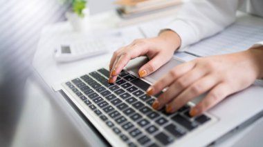 Dizüstü bilgisayar kullanan bir kadın elleri klavyede daktilo kullanıyor. Blog yazıyorum. Evde çalışan insanlar el parmaklarıyla daktilo kullanıyorlar..