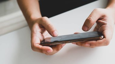 Cep telefonuyla oyun oynayan adam. Oyuncu çocuk elinde akıllı telefon, cep telefonuyla video oyunu oynuyor. cep telefonu teknolojisi e-ticaret kavramı.