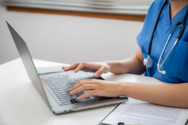 Tıp teknolojisi ekip toplantısı konsepti. Doktor elleri klavye dizüstü bilgisayarında yazıyor.