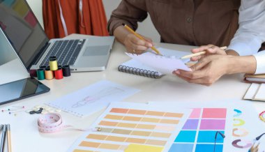 Terzide çalışan terzi kadın atölye atölyesinde moda tasarımcısı yeni elbise ve yaratıcı moda koleksiyonu tasarlıyor.